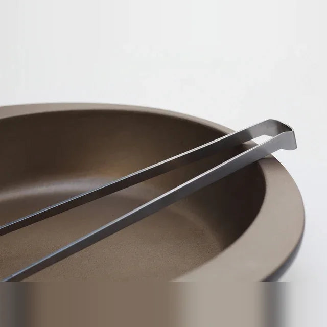 Saibashi tongs resting in a pan
