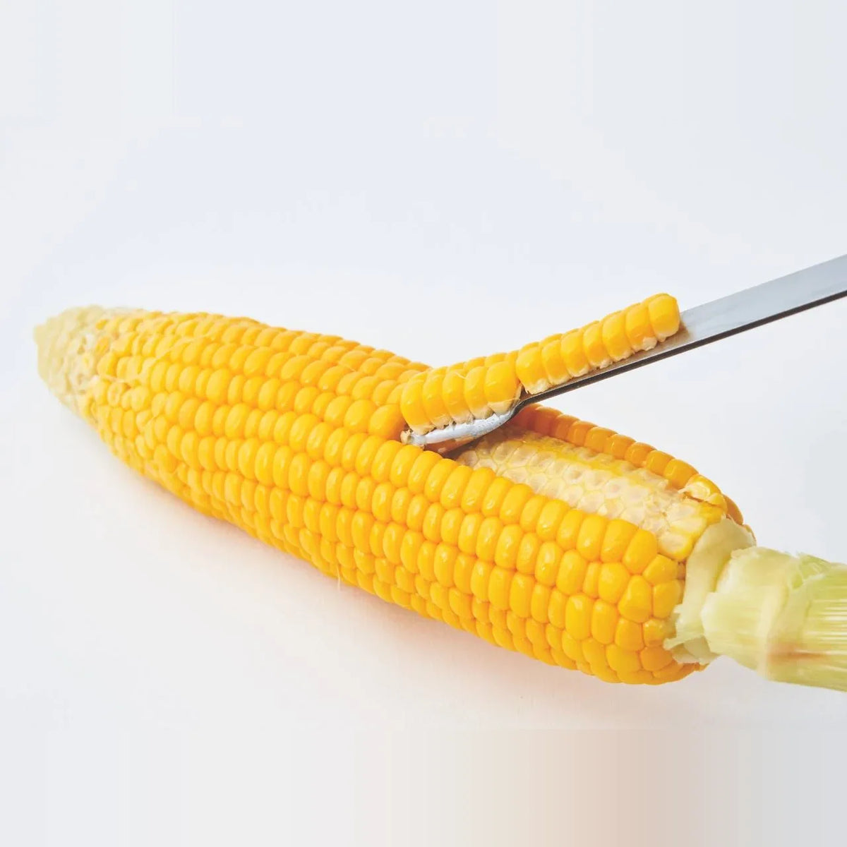 Poro corn peeler stripping kernels from a boiled cob