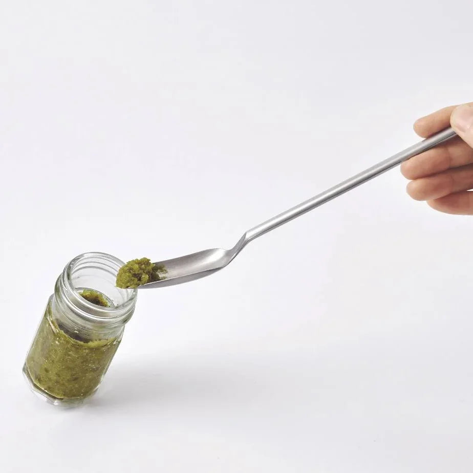 Scooping pesto from a jar with the Saji long spoon