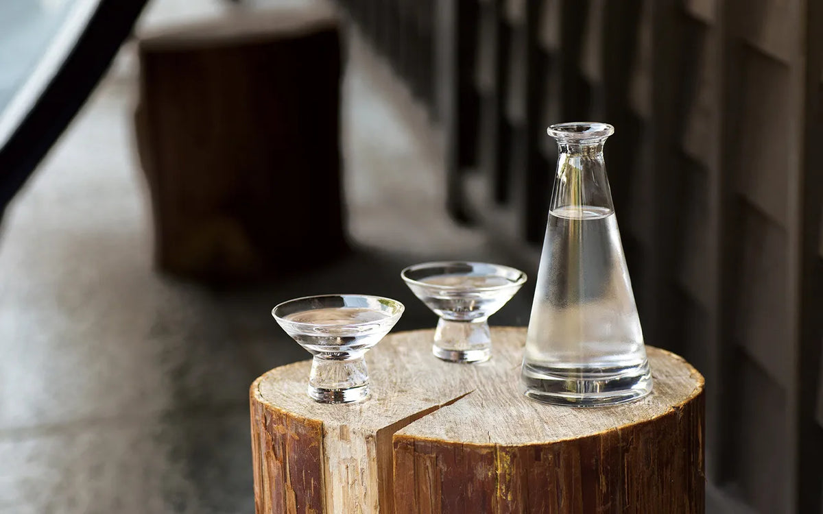 Clear Edo glass tokkuri and two sake cups in a Japanese setting