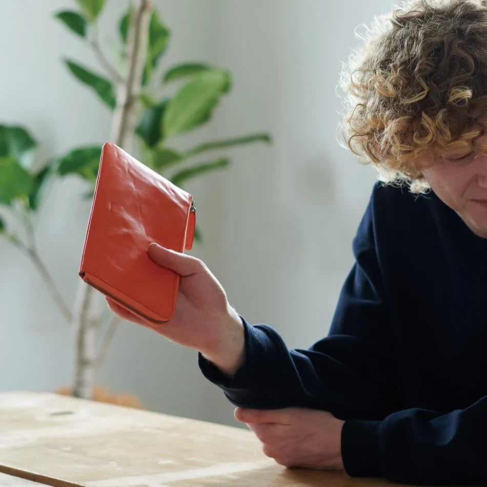 Child holding an orange hmny card wallet
