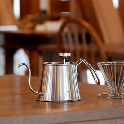 Coffee Kogu Two Drip Pot Pro in silver with a thermometer on the rim, on a wooden table