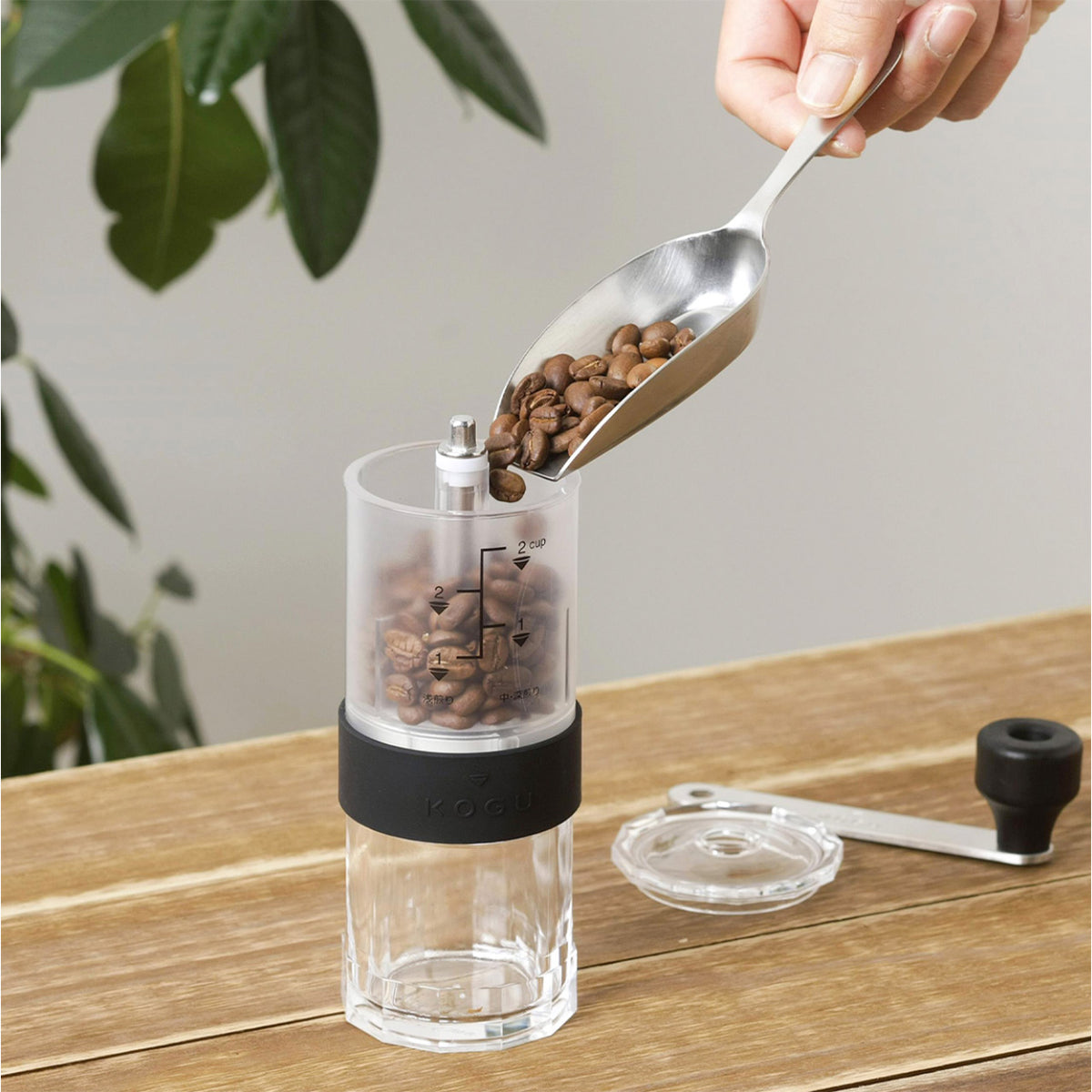 Scooping coffee beans into the manual coffee mill