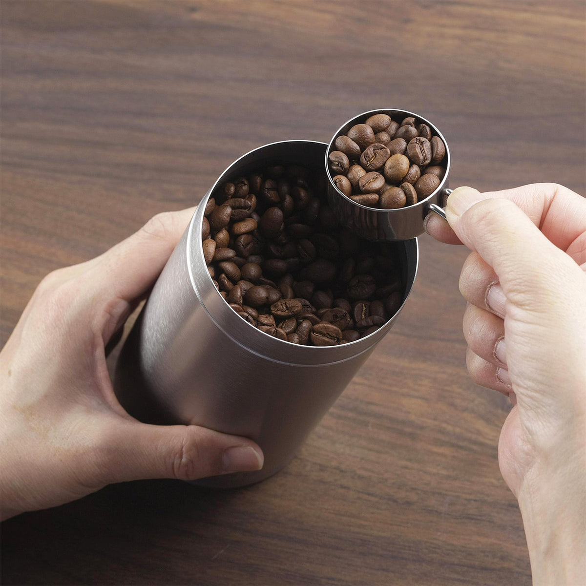 Scooping coffee beans from the large canister