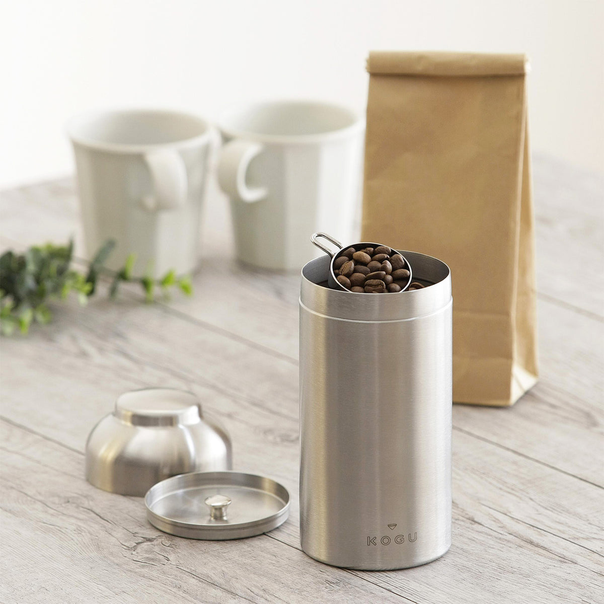 Large canister with coffee bag and cups in a kitchen