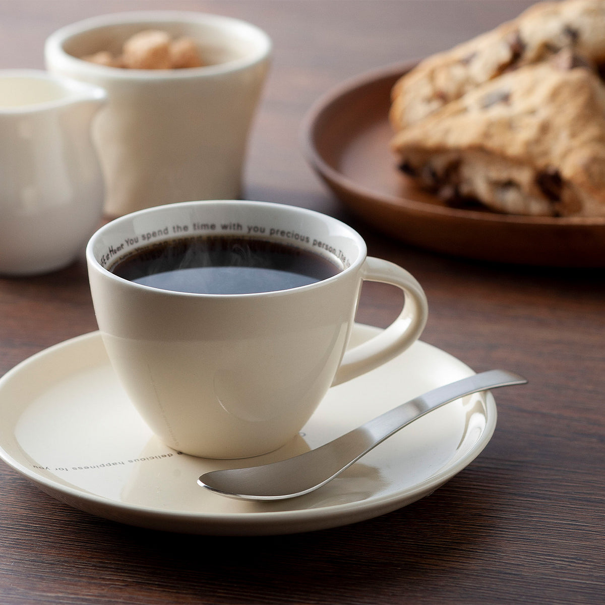 Coffee spoon on a saucer with a cup of coffee