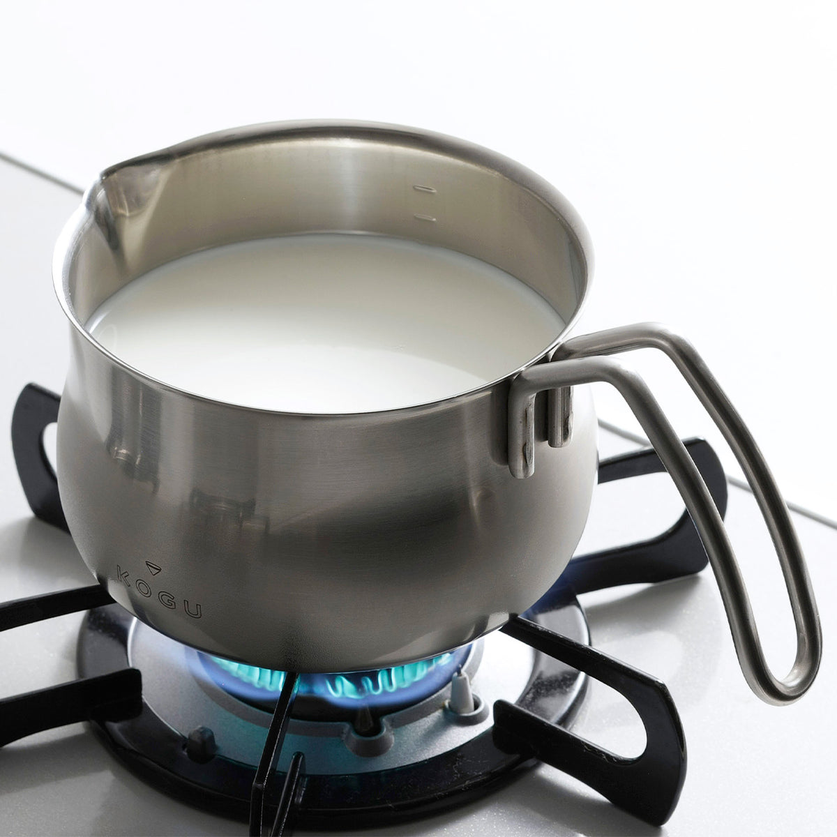 Heating milk in the milk pan on a gas stove