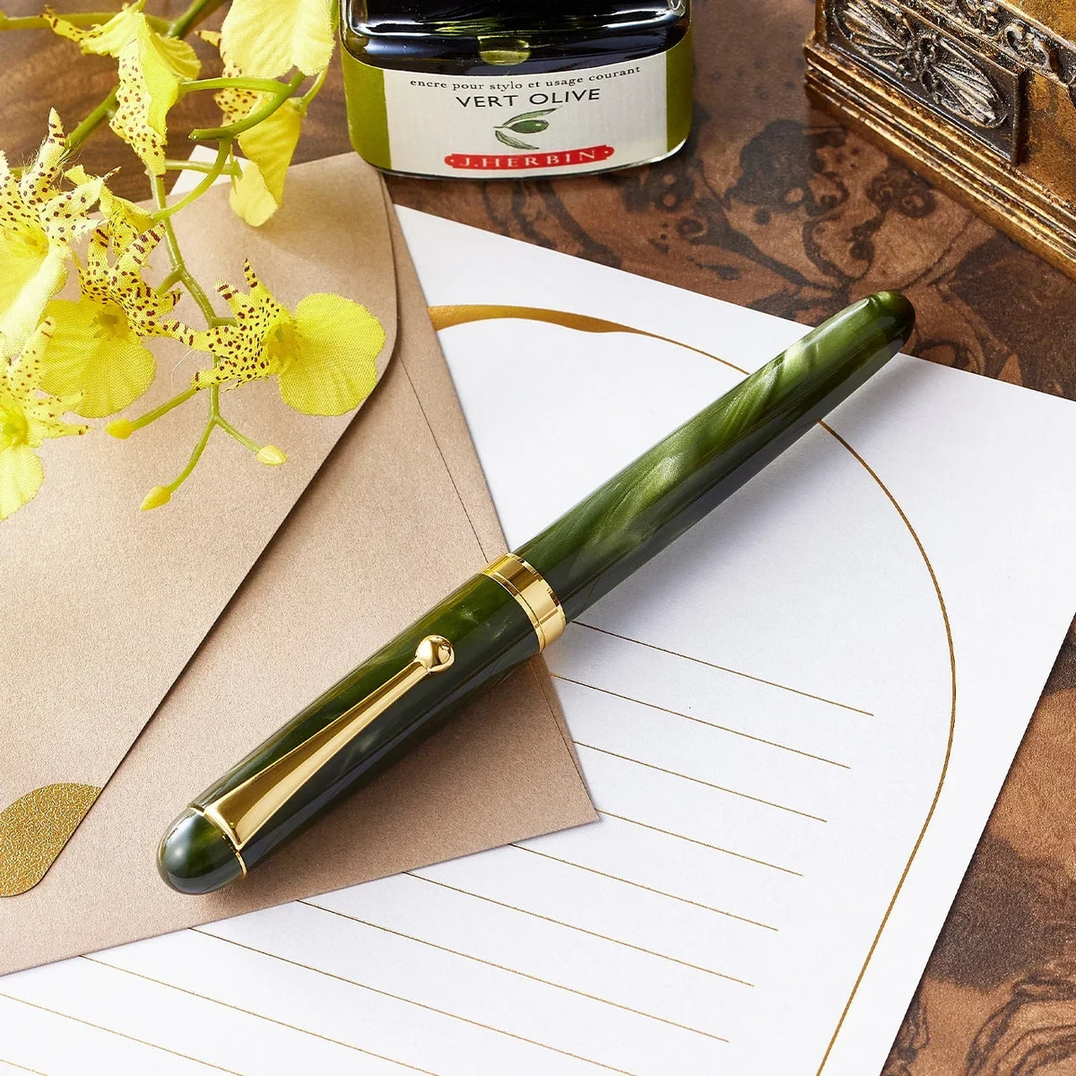 Gradation Green fountain pen on a writing desk with ink and flowers