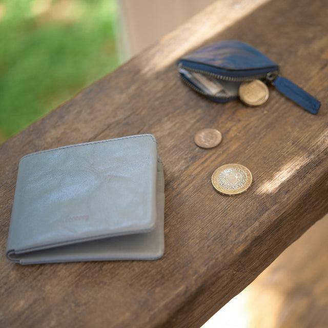 Mini coin purse holding coins and folded bills