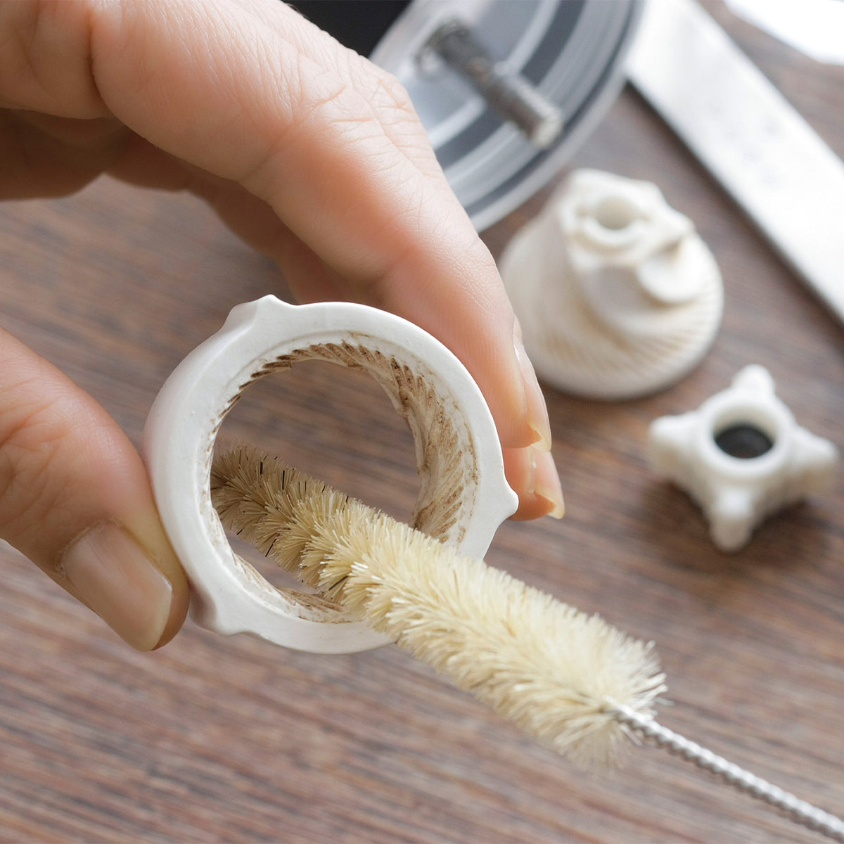 Cleaning the removable ceramic burr with a brush