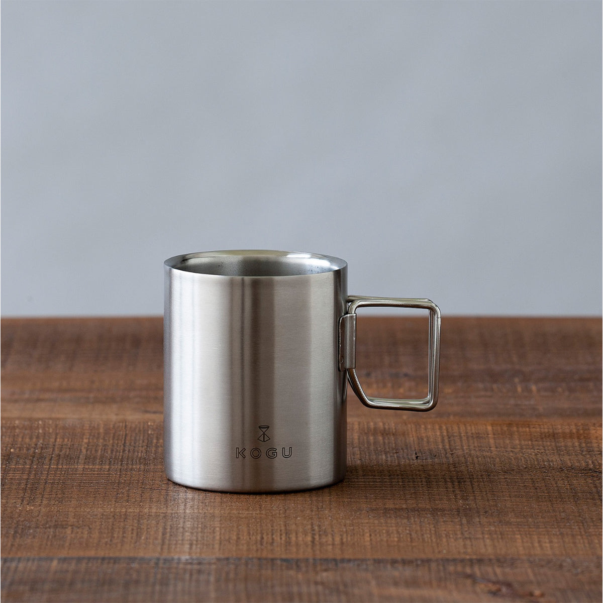 Stainless steel mug on a wooden table