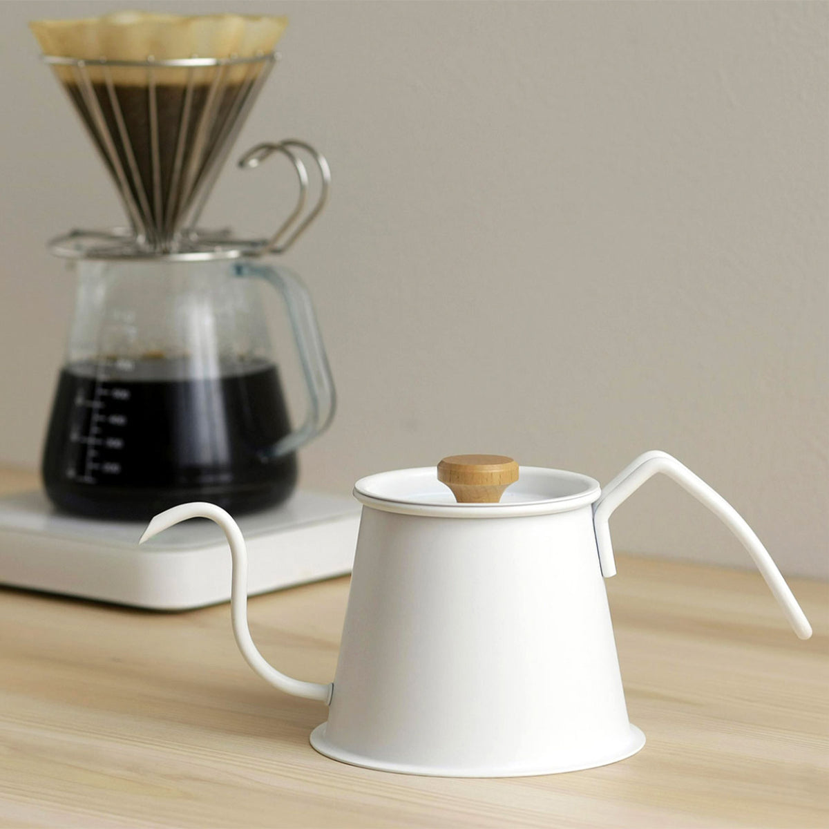 Matte white Two Drip Pot Pro next to a glass coffee server