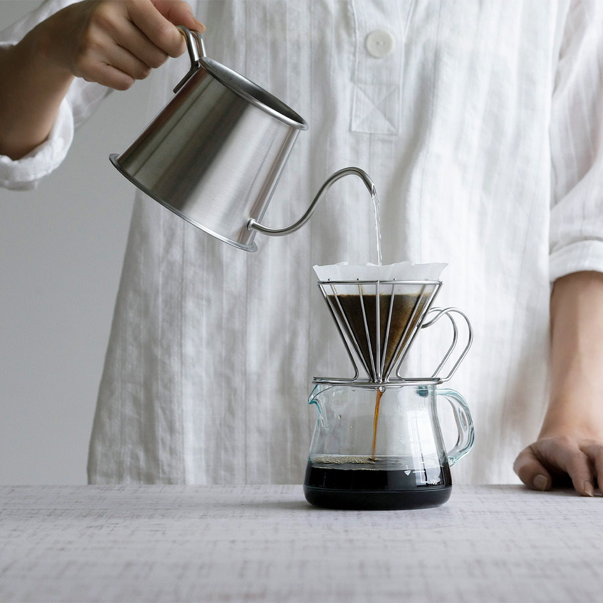 Barista pouring water in a fine stream from the Two Drip Pot Pro