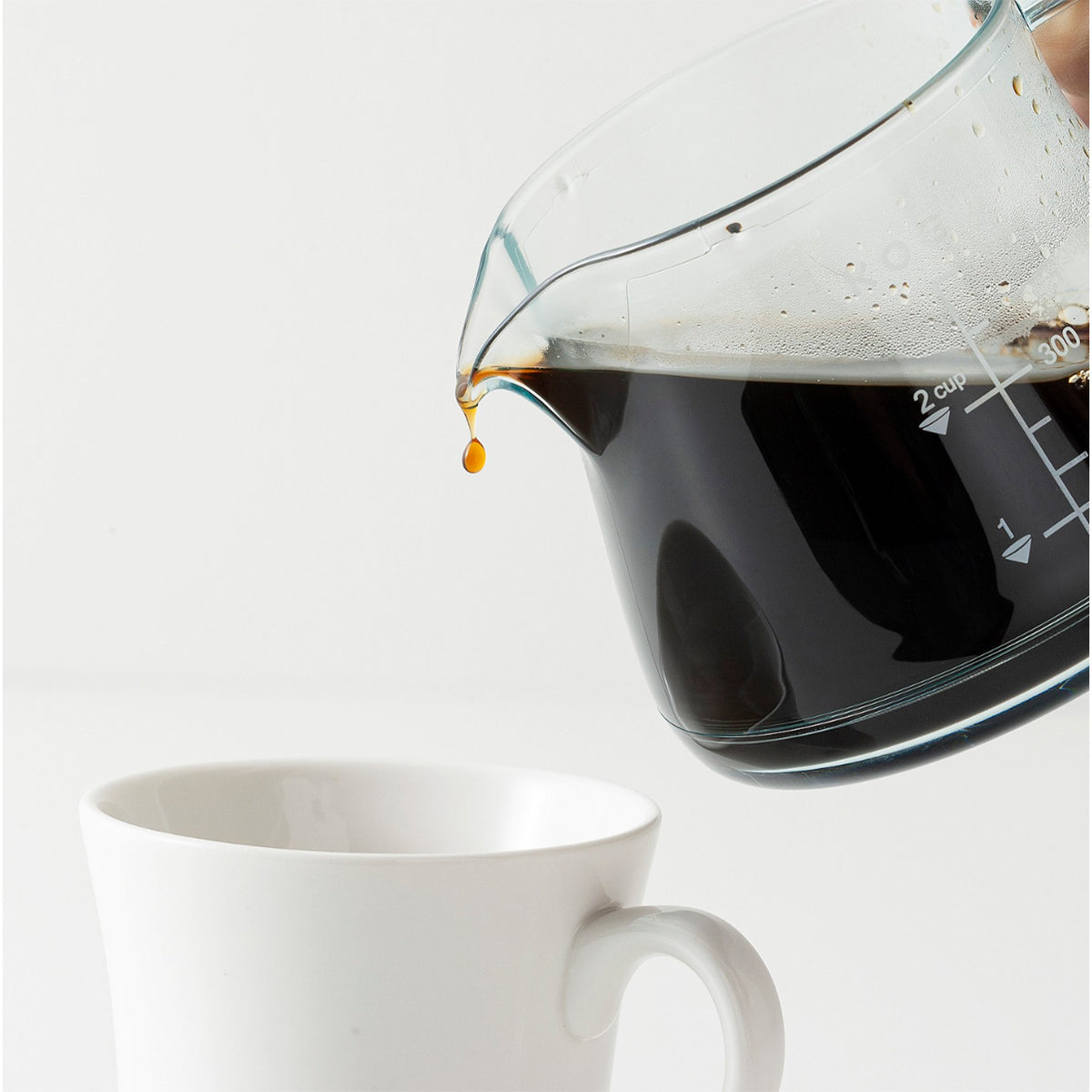 Pouring coffee from the server into a white cup