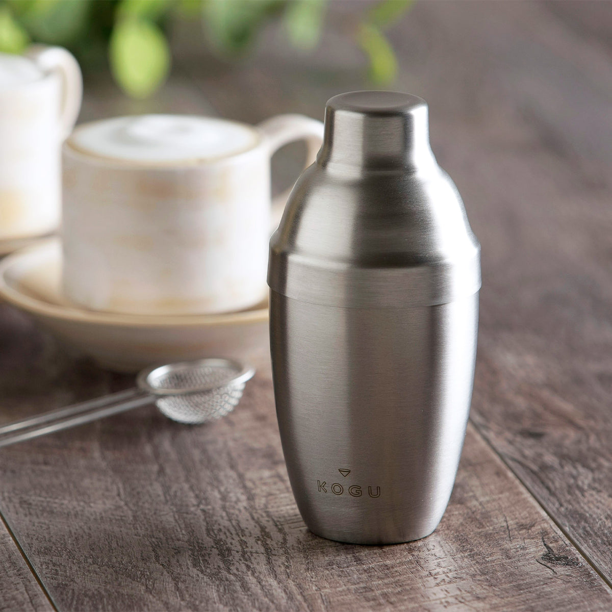 Shake de Latte stainless shaker next to a latte