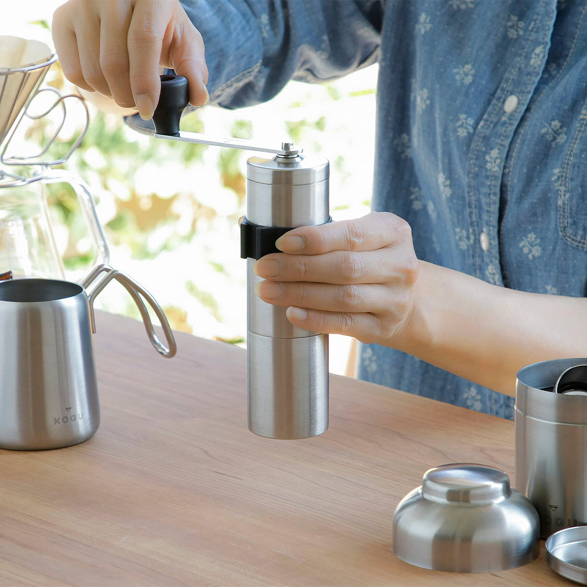Grinding coffee with the Powder Control Mill beside a drip pot