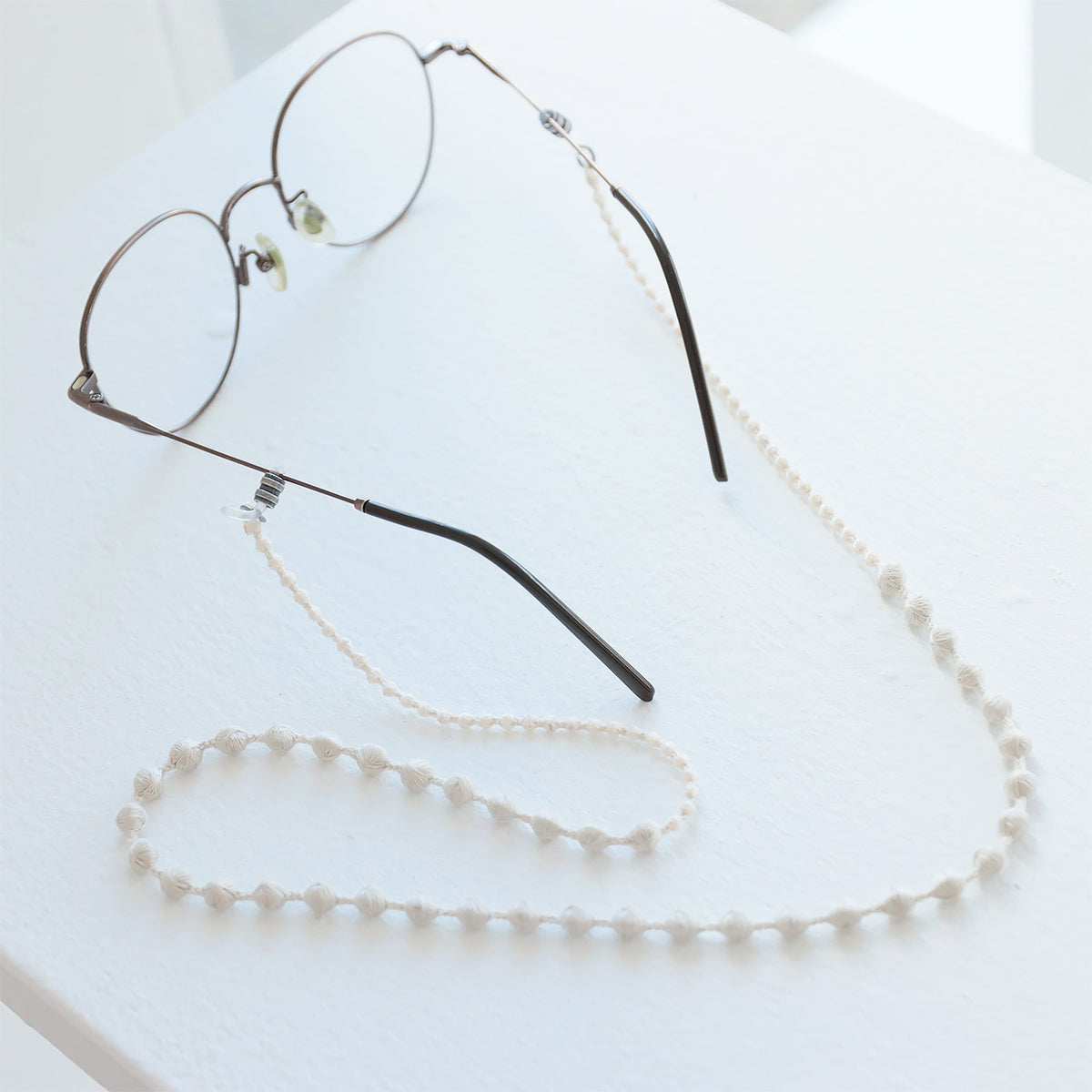 Ivory beaded glasses cord attached to eyeglasses