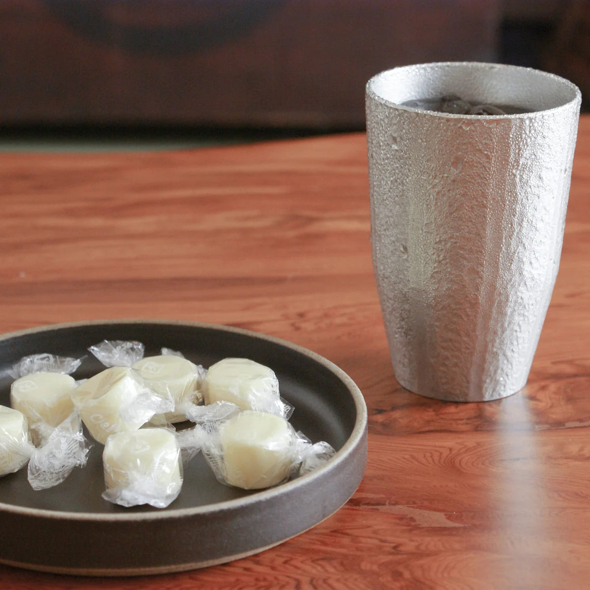 Kirameki tin tumbler with iced tea and sweets on a wooden table